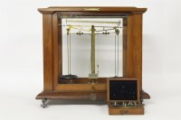 Lot 1408 - A cased balance together with a set of weights