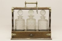 Lot 267 - An early 20th century oak three bottle Tantalus