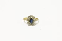 Lot 53 - A gold sapphire and diamond cluster ring with central oval mixed cut sapphire