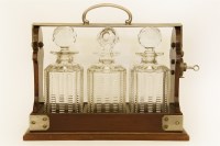 Lot 367 - A Betjemann Patent three bottle tantalus (one odd stopper)