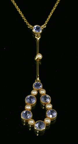 Lot 101 - An Edwardian gold sapphire and split pearl Edna May style pendant, c.1910