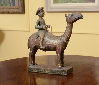 Lot 104 - A carved wooden and polychromed figure of a gentleman riding a camel