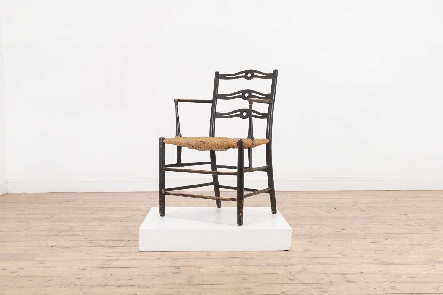 Lot 17 - An ebonised wooden elbow chair