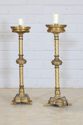 Lot 10 - A pair of tall brass candlesticks