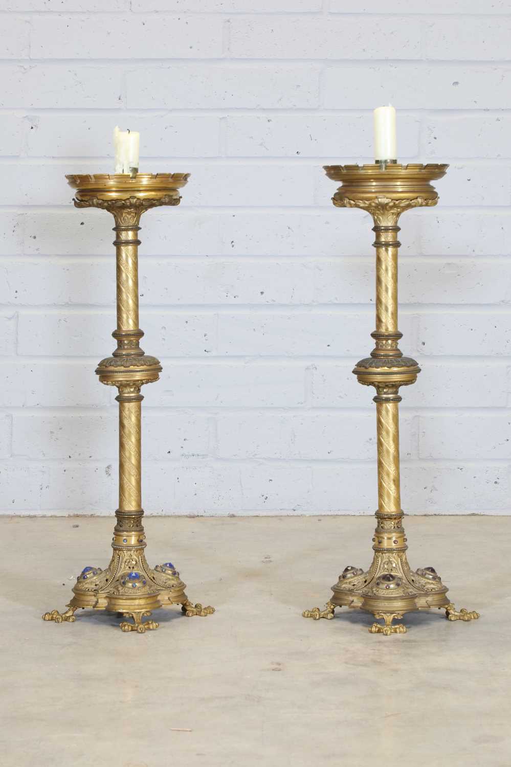 Lot 10 - A pair of tall brass candlesticks
