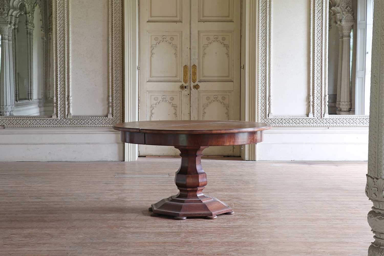 Lot 86 - A large circular walnut extending dining table