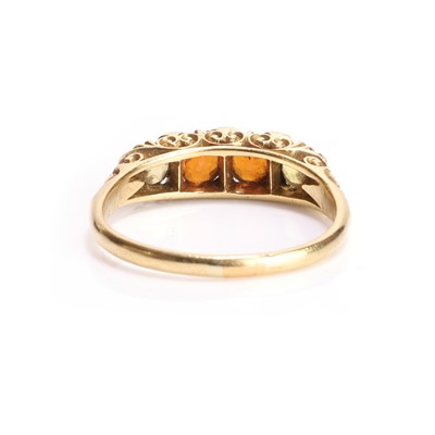 Lot 11 - A hessonite garnet and yellow gemstone carved head ring