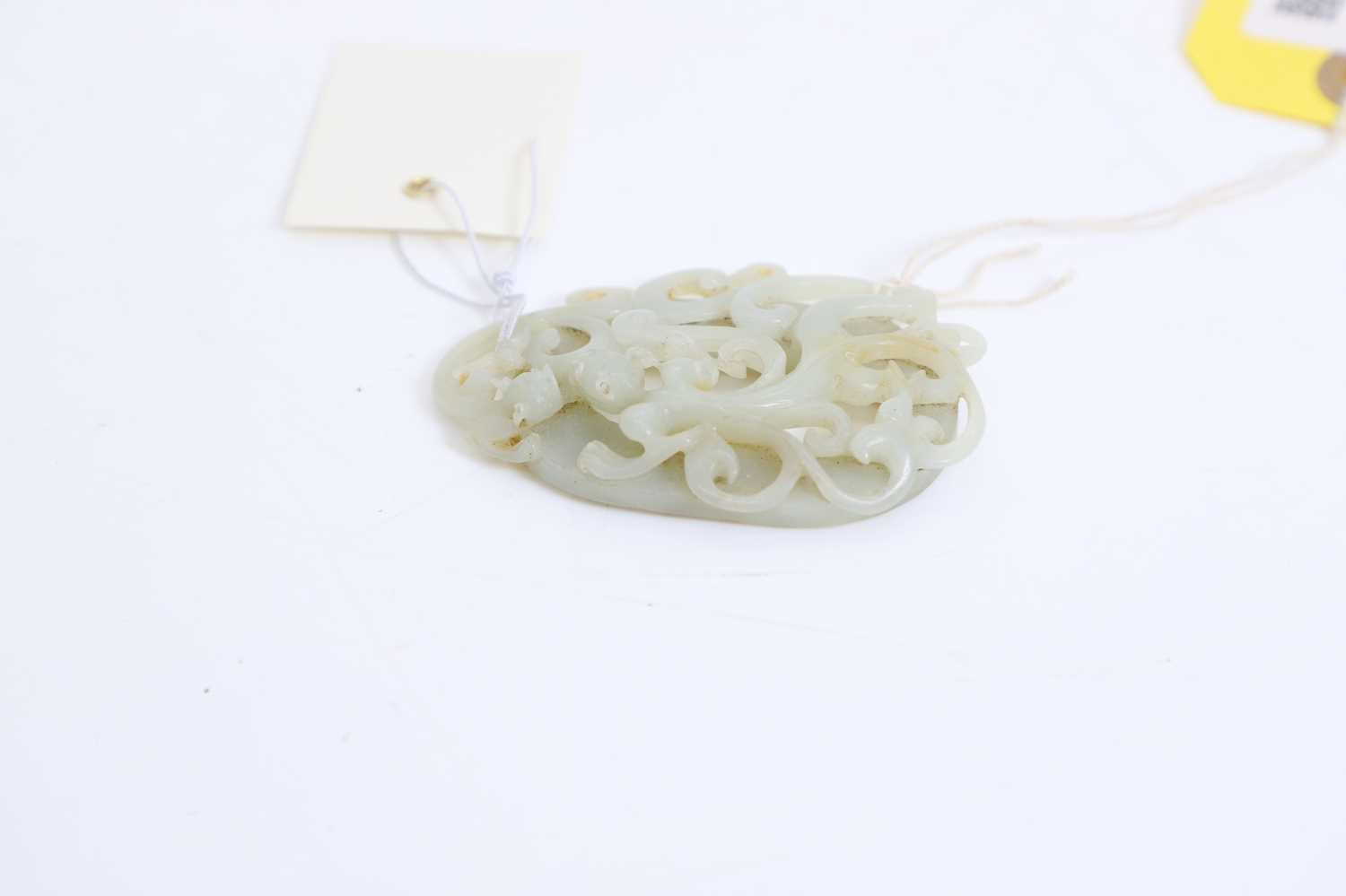 Lot 57 - A Chinese reticulated jade oval plaque