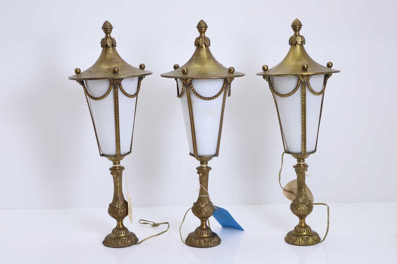 Lot 474 - A set of three brass and glass table lamps