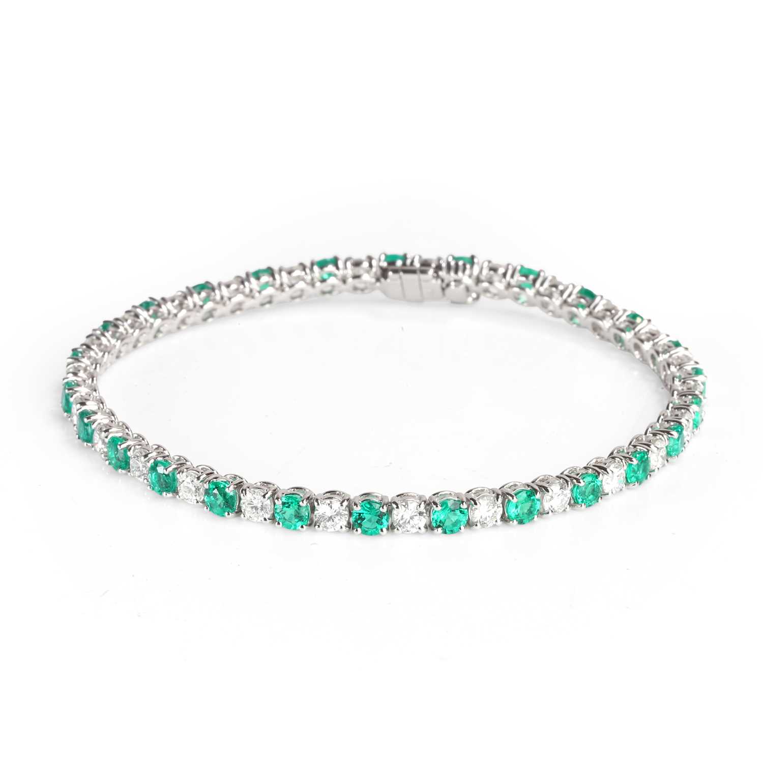 Lot 153 - An 18ct white gold emerald and diamond line bracelet