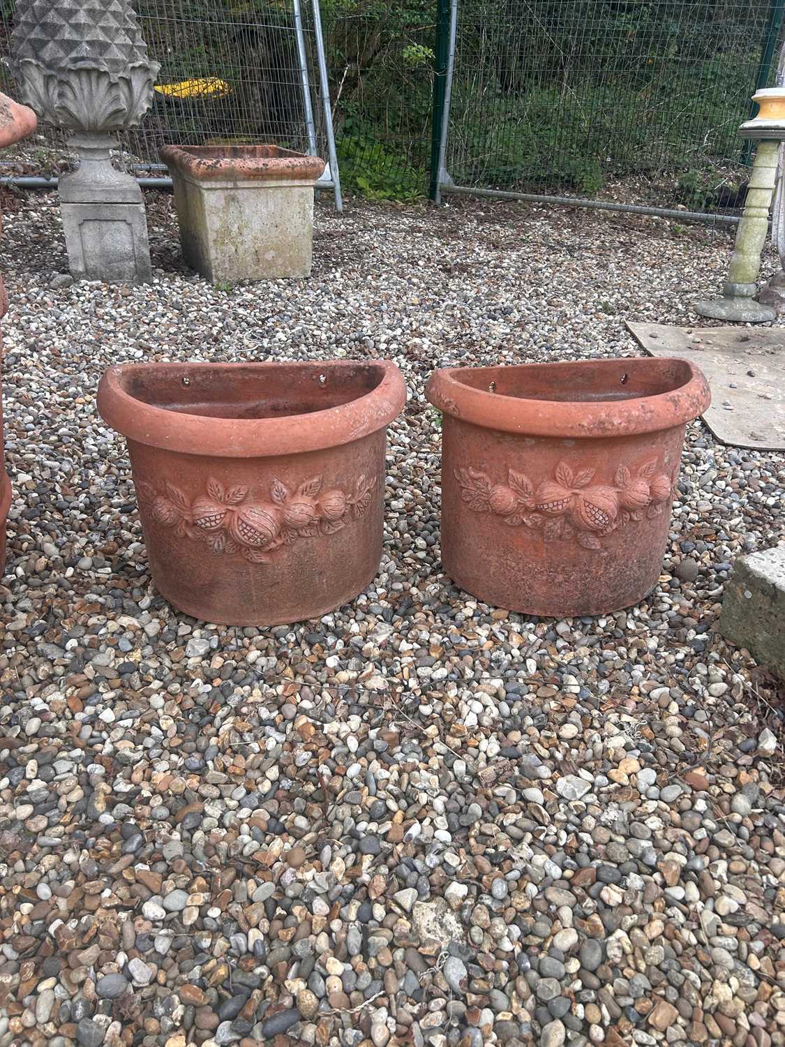 Lot 563 - A pair of demi lune terracotta planters