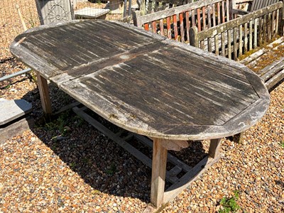Lot 557 - An oval teak garden table
