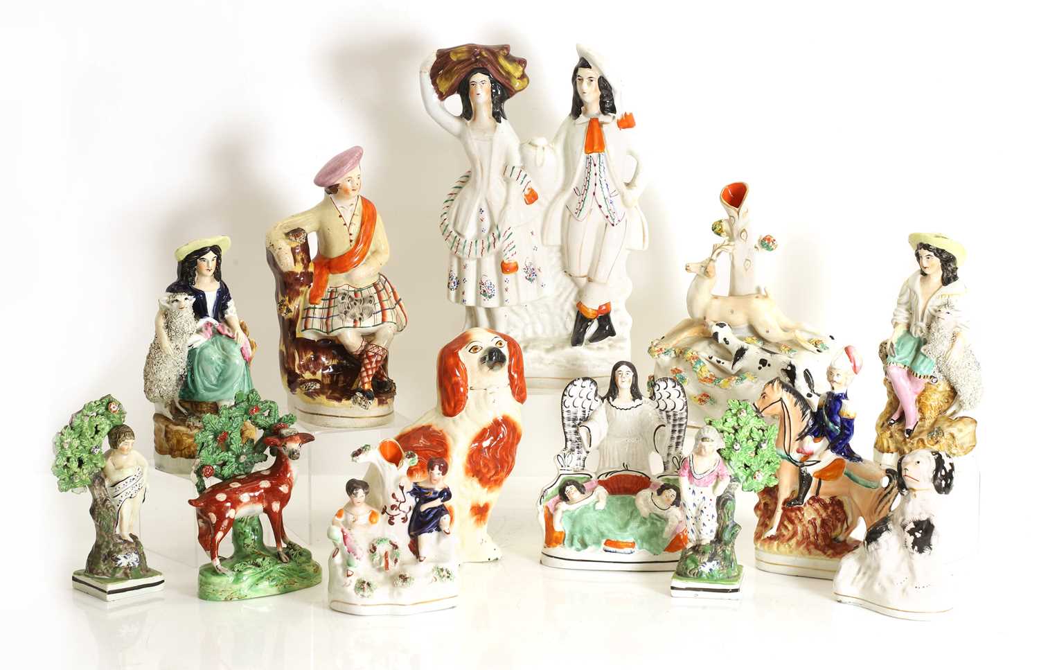 Lot 115 - A collection of nine Staffordshire and Prattware figures